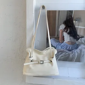 Détail du sac à main en cuir blanc crème avec de fines bretelles et boucle en métal