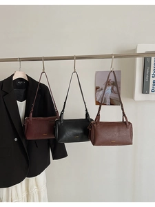 Detail view of stylish rectangular underarm bags in red, black, and brown leather finish