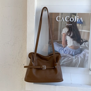 Gros plan sur le sac nuage marron plissé avec lanière réglable et anneaux argentés