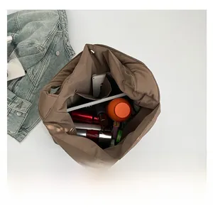 Spacious interior of brown quilted tote bag showing storage for tablet and essentials