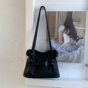 Vue détaillée du sac nuage noir avec surface en cuir texturé et bride à boucle