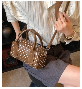 Close-up of vintage brown polka dot boston bag with polished leather and brand embossing