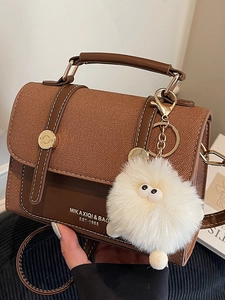 Vintage brown leather crossbody bag with top handle and white plush monster charm