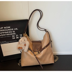 Detail view of khaki hobo bag with contrast brown trim and cute plush bunny charm