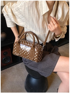 Polka dot Boston bag in brown leather finish shown on model with striped shirt