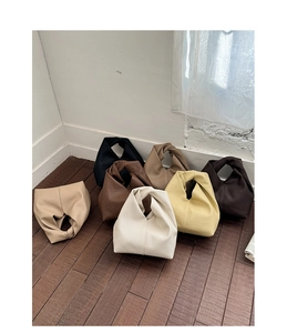 Détail de sacs seaux colorés avec poignées nouées et cuir à grain litchi de haute qualité