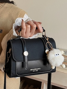 Retro black canvas and leather crossbody bag with white stitching and plush charm