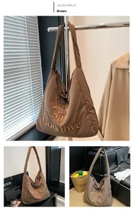 Detailed macro view of brown quilted puffer tote bag with Never Say Goodbye embroidery