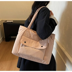 Detail of soft padded apricot tote bag with large front pockets and black buttons