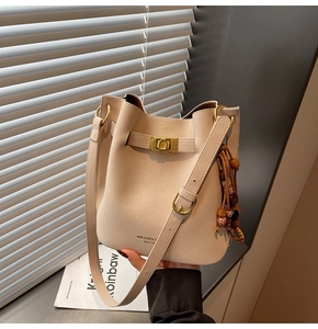 Détail du sac seau en cuir crème avec fermoir doré et perles en bois style bohème