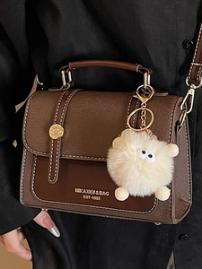 Vintage dark brown crossbody bag with contrast stitching and plush doll pendant for women
