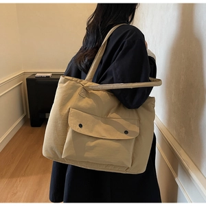 Detail view of khaki large capacity tote bag with front pocket and snap buttons