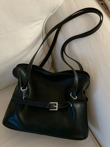 Sac fourre-tout noir minimaliste avec boucle argentée et détail de ceinture sur fond textile