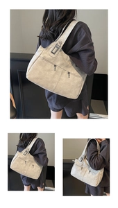 Detailed macro view of vintage beige tote bag with metallic zippers and textured faux leather