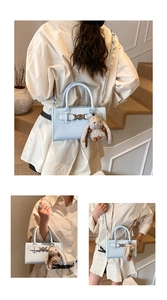 Détails du sac bandoulière en cuir verni bleu clair avec anneau et breloque lapin