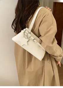 Détail du sac baguette en similicuir blanc cassé avec breloque étoile et bandoulière