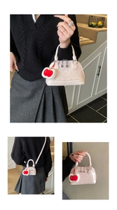 Nahaufnahme der rosa Handtasche mit Herzmuster, glänzendem Lack und Apfel-Anhänger