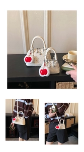 Detailansicht weißer Taschen mit roten Punkten und Apfel-Anhänger-Accessoires