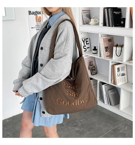 Close-up of brown tote bag with Never Say Goodbye embroidery on premium nylon fabric