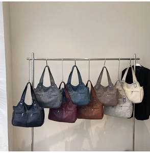 Detailed display of vintage tote bags in various colors with metallic zipper pockets