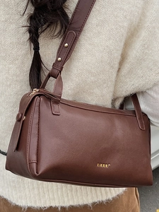 Classic brown leather baguette shoulder bag with gold logo and wide strap for casual wear