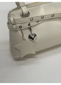 Détail du sac en cuir blanc crème avec pendentif coeur et garnitures argentées