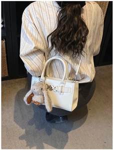 Vue détaillée du sac blanc texture crocodile avec boucle argentée et charm lapin