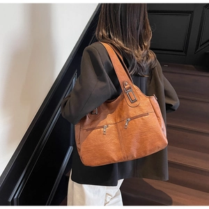 Close-up of a large brown vintage tote bag with functional double zipper front pockets