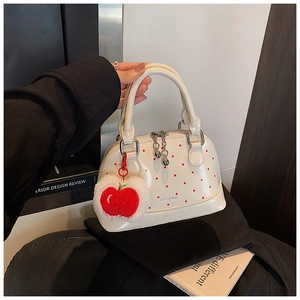 Polka dot handbag with silver hardware and a red plush apple charm detail