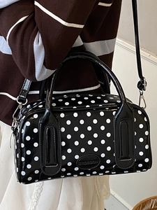 Chic black and white polka dot boston handbag with glossy finish and crossbody strap
