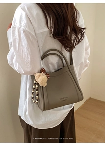 Detail of taupe litchi grain bucket bag with cute bear charm and colorful beads
