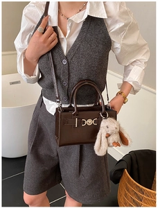 Détail du mini sac en cuir verni marron avec boucle coeur et charm lapin en peluche