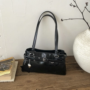 Détail d'un sac vintage noir en similicuir avec breloques étoiles et boucles