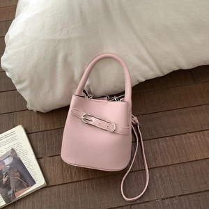 Detailansicht der rosa Litschi-Lederstruktur und Metallschnalle dieser Eimer-Handtasche