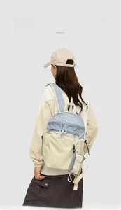 Detail view of lightweight light blue hiking backpack with drawstring side pocket and mini pouch