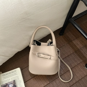 Detail der beigefarbenen Beuteltasche aus Leder mit Silberschnalle und Griff