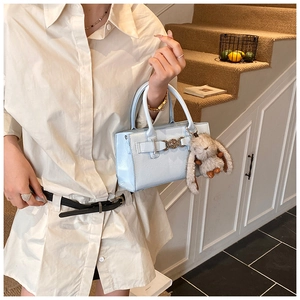Détail du sac bandoulière en cuir brillant bleu clair avec un charmant lapin en peluche