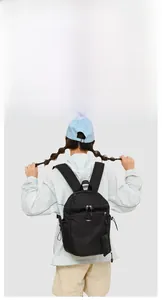 Outdoor backpack shown on model featuring multiple zipper compartments and durable nylon fabric