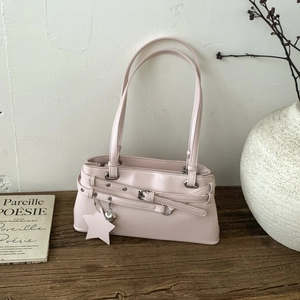 Détail du sac rétro beige avec boucles décoratives, pendentif étoile et cœur en métal