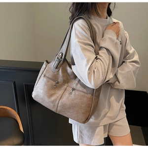 Detail of brown PU leather tote bag with double front zippers and vintage hardware