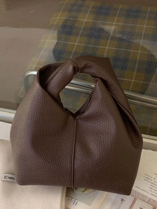 Sac à main minimaliste en cuir marron foncé avec une poignée nouée élégante