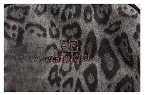 Detailed macro view of the high-density leopard print fabric and red logo embroidery
