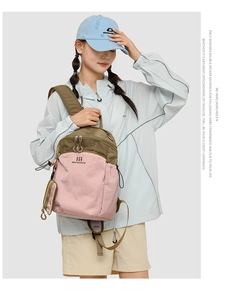 Detail view of pink and olive green hiking backpack with waterproof nylon texture