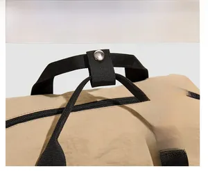 Détail de la poignée en nylon avec bouton-pression en métal argenté sur un sac à dos de voyage