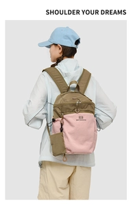 Pink and khaki waterproof hiking backpack shown from the back on a model in nature