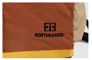 Gros plan du sac à dos patchwork tricolore élégant avec tissu de qualité et logo brodé