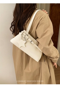Détail du sac à épaule rétro beige minimaliste avec pendentif étoile sur modèle