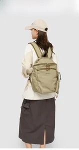 Detail view of khaki lightweight nylon outdoor backpack with adjustable side drawstrings