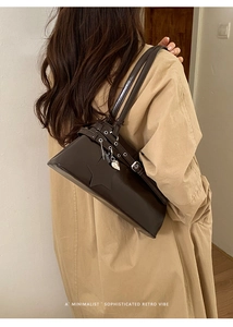 Détail d'un sac à bandoulière rétro marron foncé avec œillets et pendentif étoile