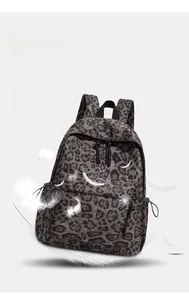 Leopard print backpack detail surrounded by feathers showing its lightweight canvas material